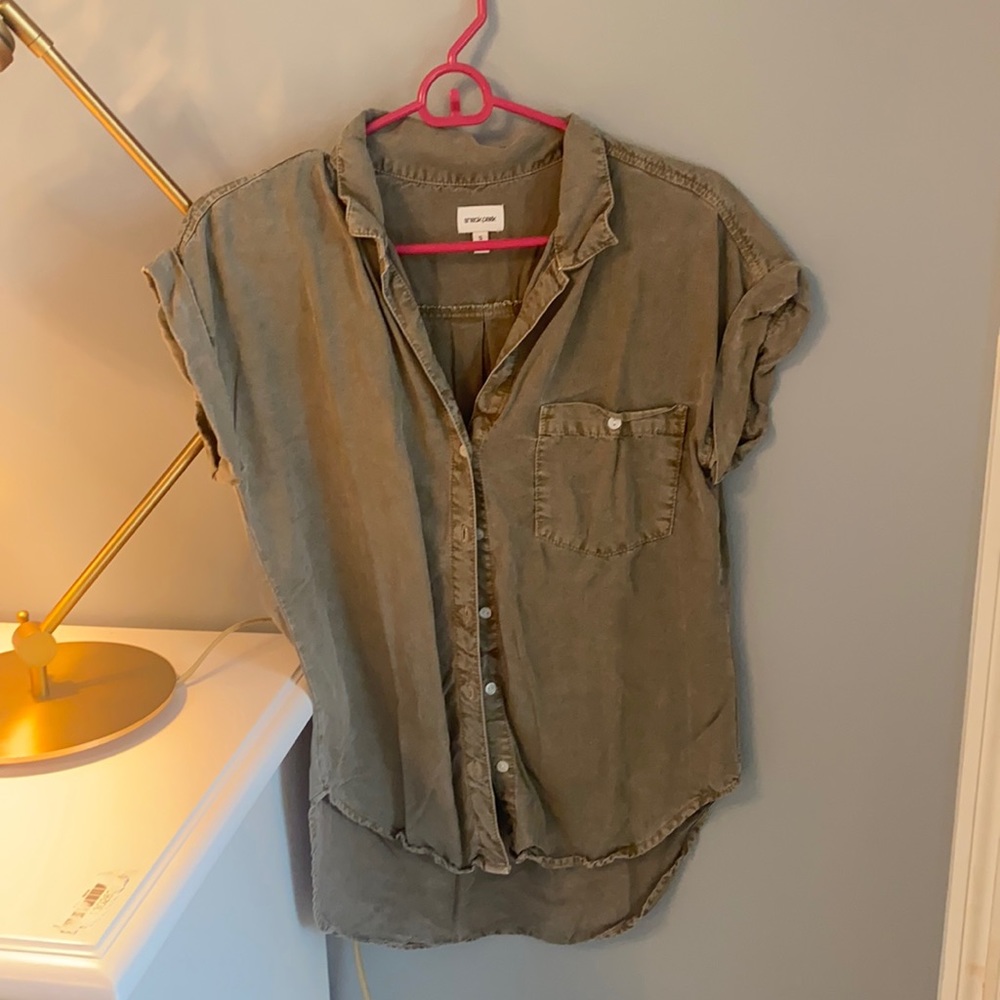 Green button up shirt, folded sleeves.